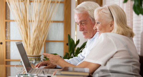 Two older people using a laptop